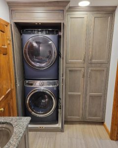 bath and laundry remodel with stacked washer dryer in a built-in cabinet with doors