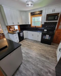 black and white kitchen black brick backsplash and white cabinets